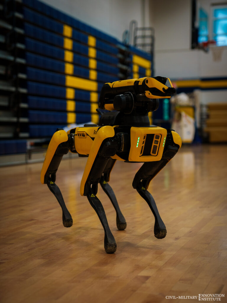 Photograph of robotic dog in gymnasium. 