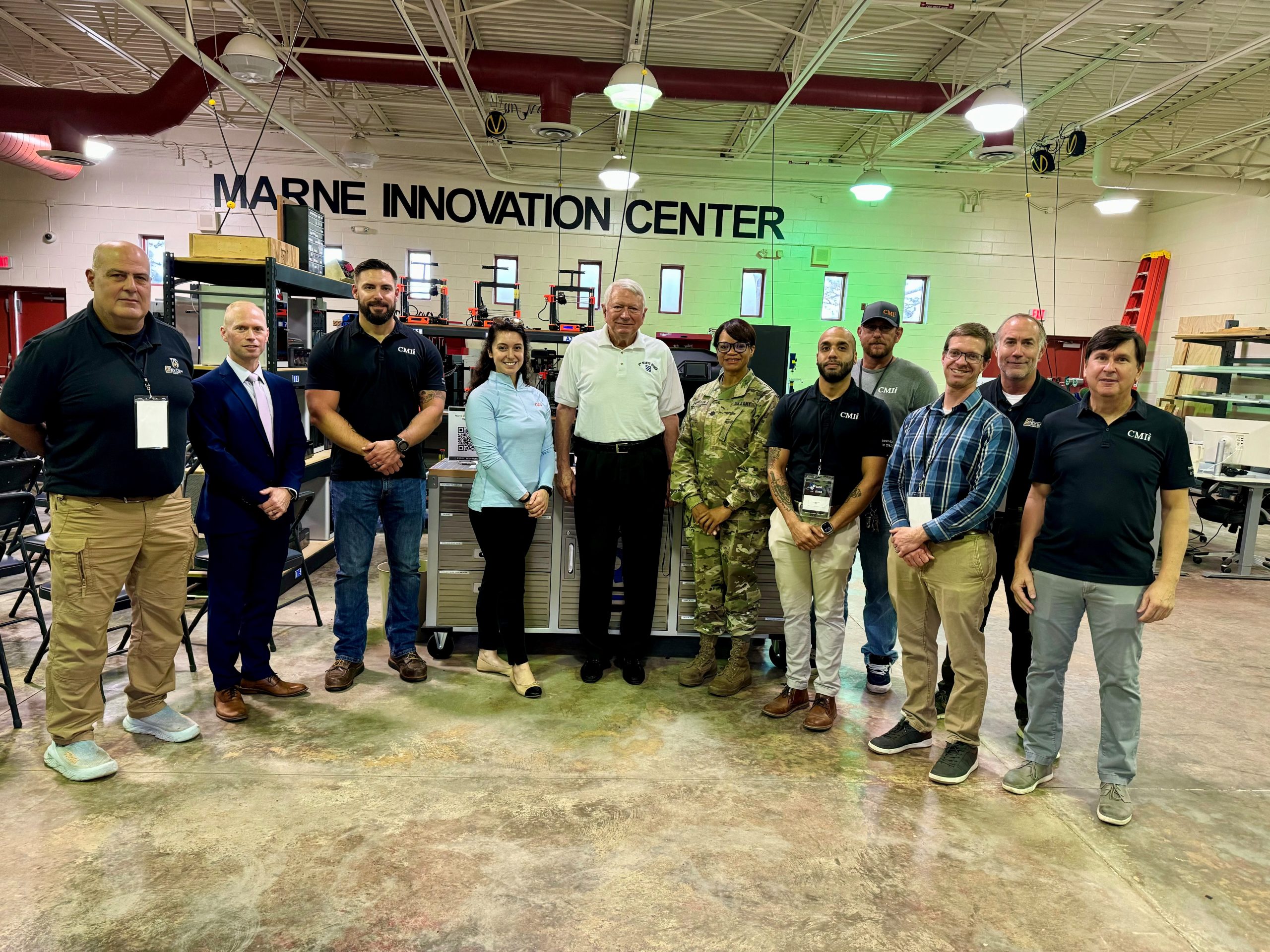 A group of men and women stand in the Marne Innovation Center. 