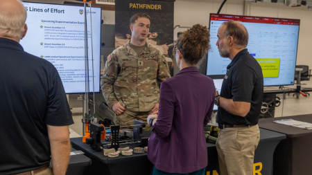 Soldier speaks to civilians at a display